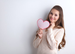 Portrait of beautiful happy woman holding a symbol heart.